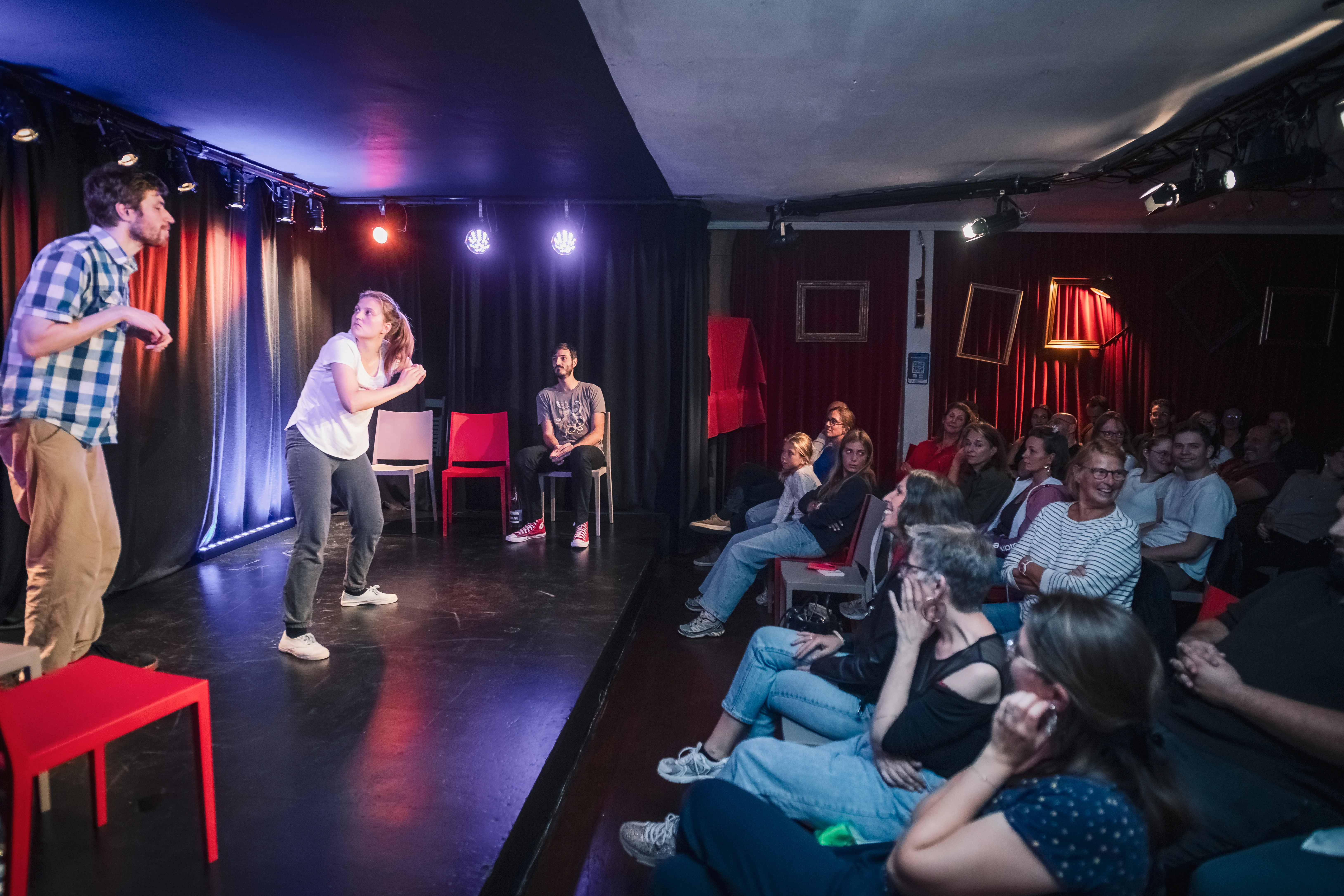 Une comédienne joue face au public dans une salle comble.